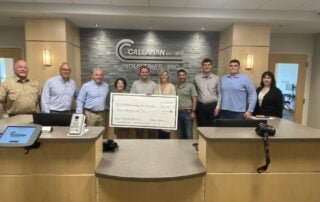 Donor Highlight Photo of Callanan Industries. Employees from Callanan Industries are holding a large check and smiling.